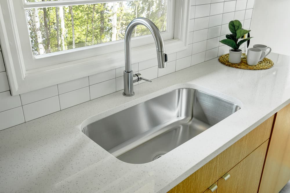 white quarts countertop with stainless steel sink